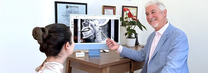 Chiropractor San Luis Obispo CA Christopher Tabick Pointing To X-Ray With Patient Our Difference